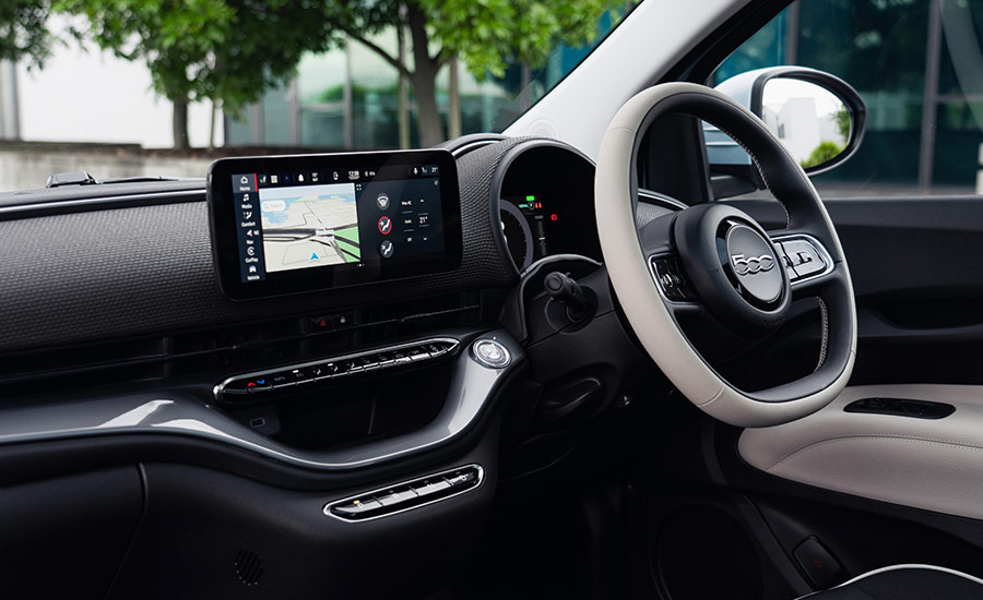 The interior of a Fiat 500e electric car, focusing on the dashboard and driver's seat
